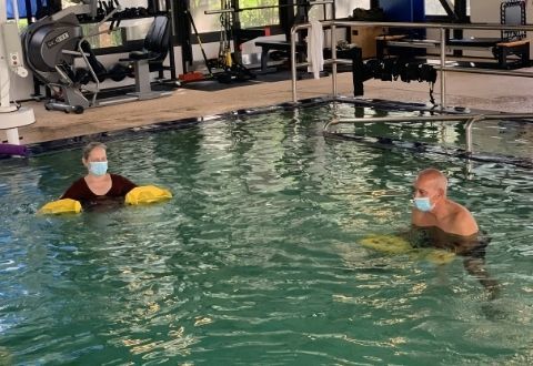 Man and woman with floats in therapy pool