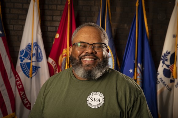 Smiling Veteran in front of flags