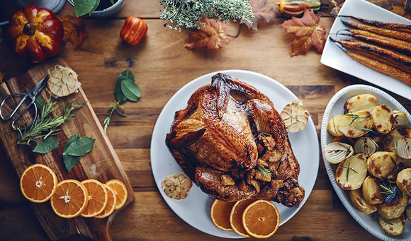 dining table set-up with turkey, and other holiday meals