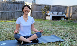 woman doing yoga on mat smiling