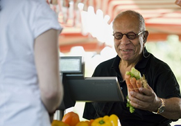 A Veteran grocery shopping, buying carrots and celery 