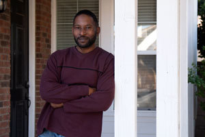 man standing on porch looking at camera