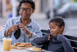 Grandmother and Granddaughter eating on an outdoor patio 