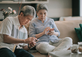 A Veteran and partner looking at their phones 