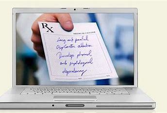 Aphoto of a laptop and on the screen is a hand showing a prescription written on an RX note