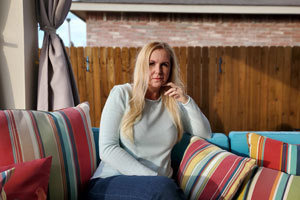 woman sitting on outdoor couch looking at camera