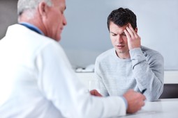 Doctor talking to man with headache