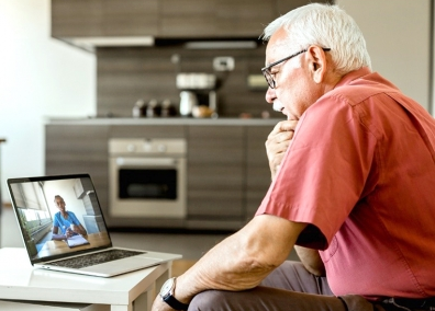 An older man looks at a computer