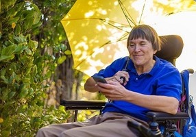Veteran in wheelchair receiving text message appointment reminder on her cell phone