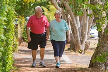 Couple holding hands while walking down a sidewalk 