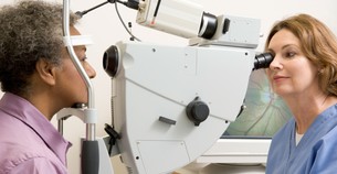 Optometrist conducting eye test on patient