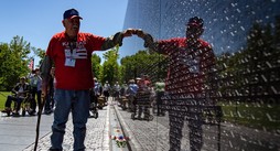 Veteran at Vietnam Wall with other Veterans