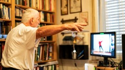 Senior Veteran following exercises on computer monitor