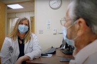 A Veteran talks with his doctor at VA.