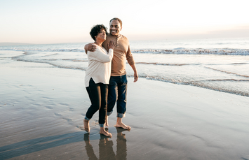 A Veteran and their partner walking on a beach