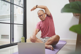 senior adult man training and stretching arm with Laptop