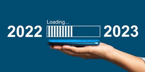 Hand holding a cell phone with a progress bar loading updates from 2022 t0 2023