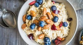 A bowl of oatmeal with fruit and nuts