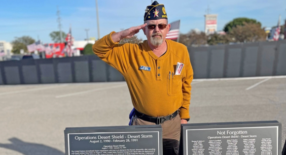 Older man in military cap saluting