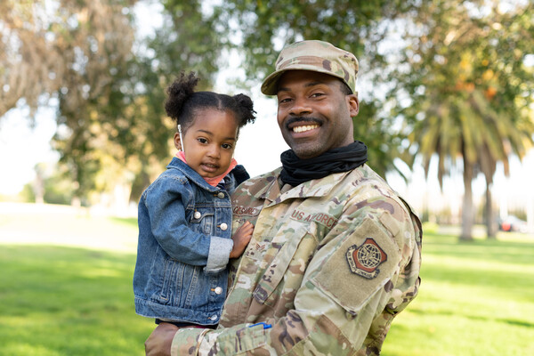 Senior Airman Jerry Cesaire poses for a photo with his daughter