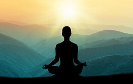 Yoga silhouette against mountain sunset