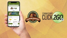Hand holding mobile phone showcasing the Commissary App