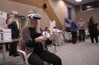 Woman sitting in a chair wearing virtual reality goggles