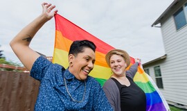 Two LGBTQ  women with Pride flag