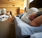 Man laying in homeless shelter