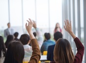 Women raising their hands in a seminar