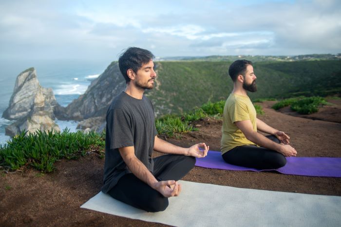 Two men doing yoga outside