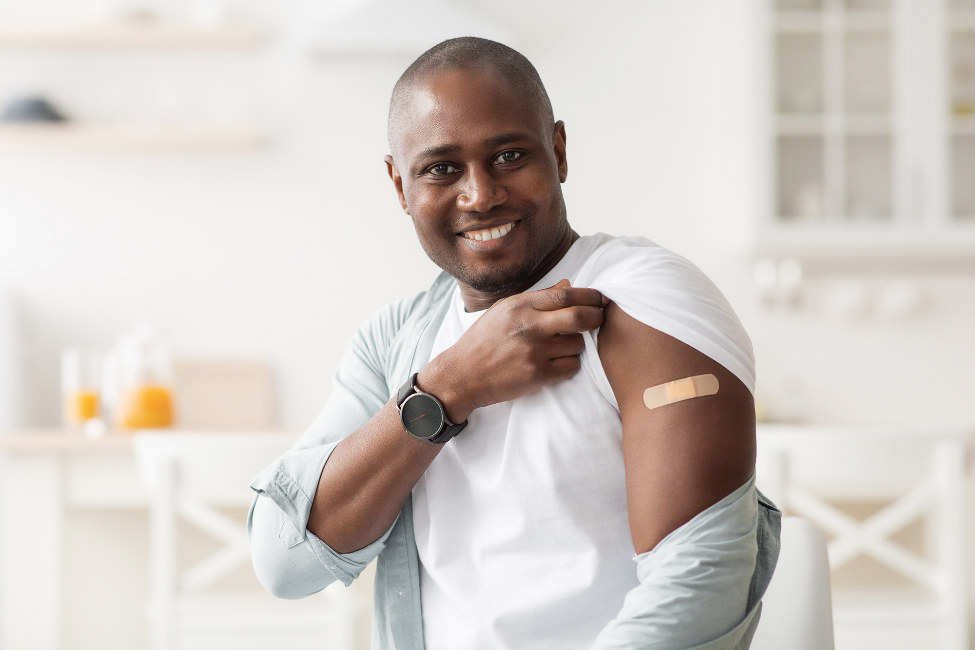 African-American man with a bandage on his arm from a vaccination.