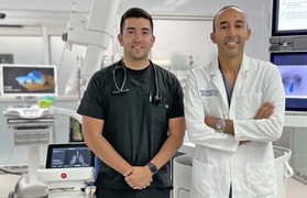two doctors stand in front of medical equipment