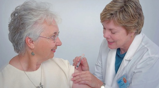A woman receiving an injection from a health care worker