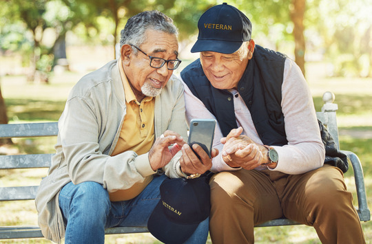 Two elder Veterans looking at a cell phone