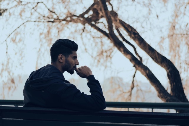 Man sitting on bench thinking