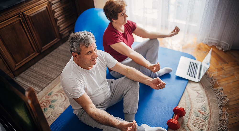 Older man and woman performing a yoga pose 