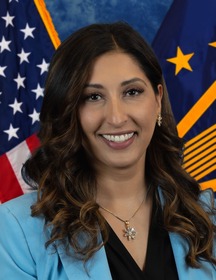 Woman smiling with flags behind her