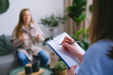 Therapist taking notes while talking to patient