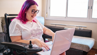 Woman in a wheelchair working at home