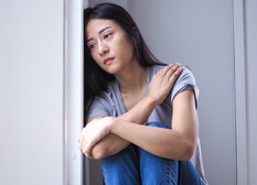 Depressed asian lady looking out the window.