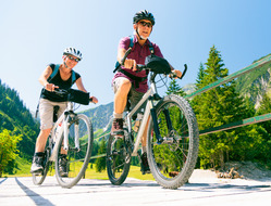 Senior couple biking in the mountains together.