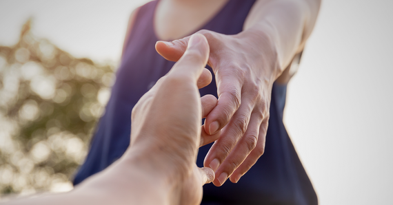 Hands of person helping another person.