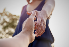 Hands of person helping another person.