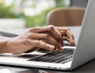 Hands typing on a laptop.