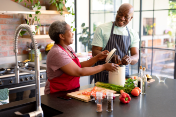 Two people prepare food in the kitchen.