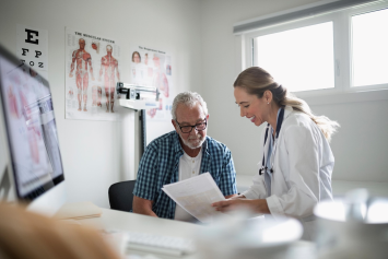 A medical professional reads from a chart to a person.