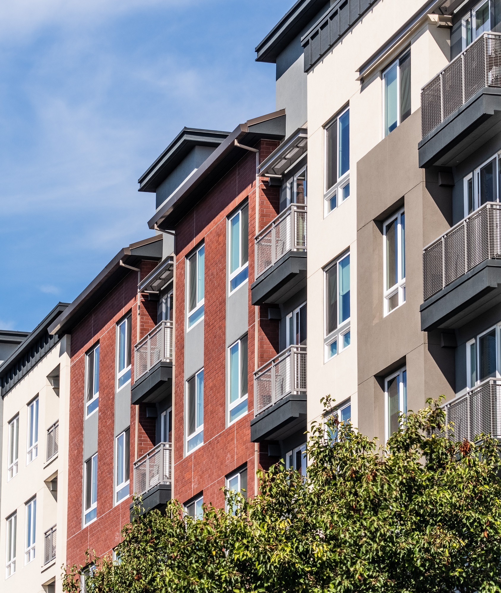 A row of modern apartment buildings featuring multiple balconies, showcasing urban living and architectural design.