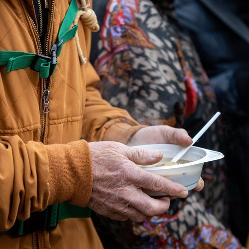 Hands holding a bowl of soup