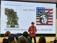 person in front of big screen with image of Statue of Liberty 